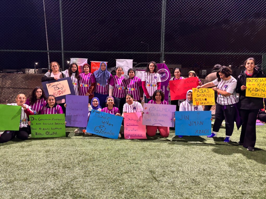 7- Women took to the field carrying banners they created at a workshop held a few days before the match.